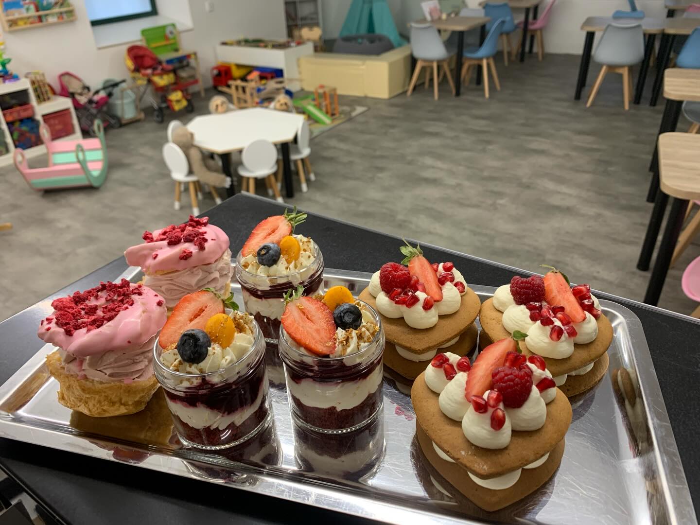 Barevné domácí dezerty a kelímky s jahodami v herničce