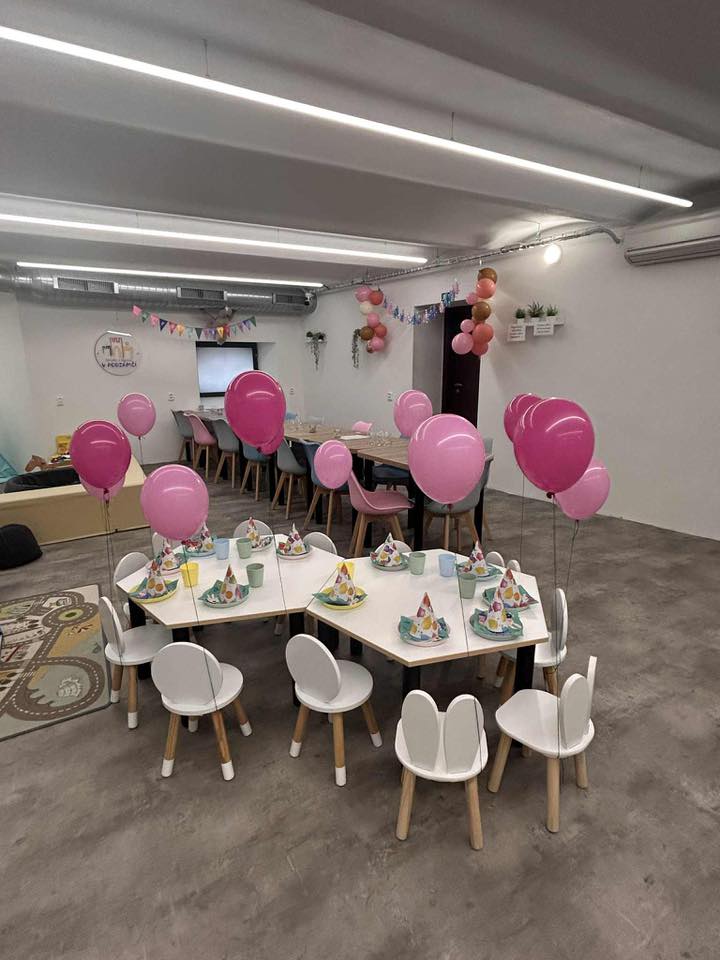 Narozeninová oslava v herničce — růžové balónky a prostřený stůl